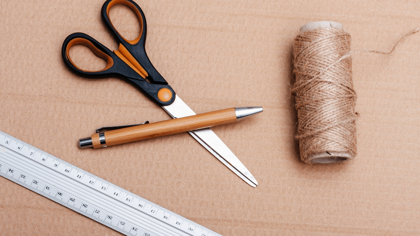 a string and a ruler with scissor and pen