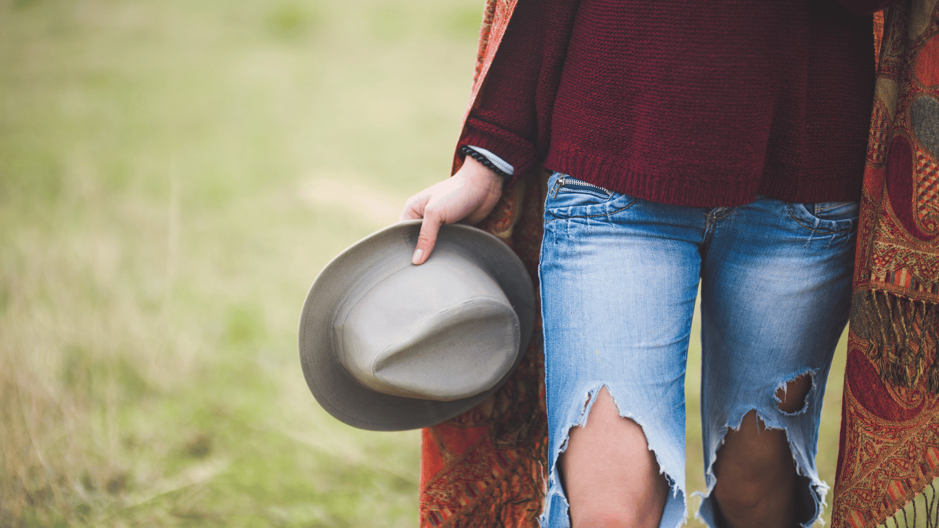 woman holding hat accessorized with a scarf