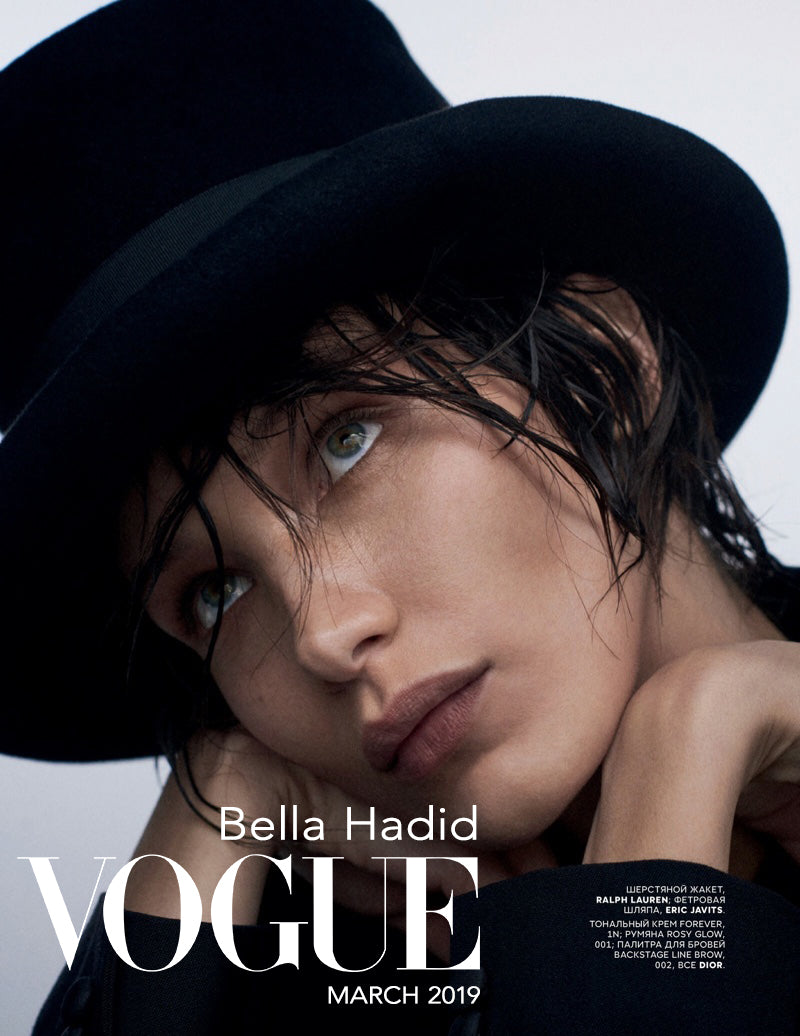 Vogue magazine cover featuring Bella Hadid with a black hat on a light gray background