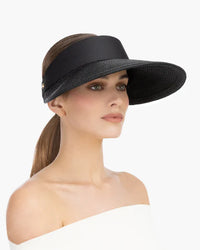 Woman wearing a wide-brimmed black visor hat., visirs, eric javits champ ii