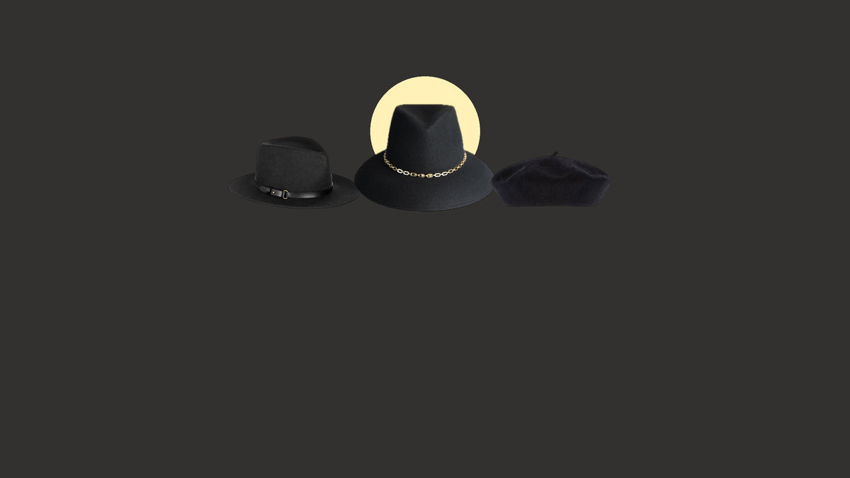 Three black Eric Javits hats, the Legend and Jamie felt fedoras and the Tanya wool beret, in front of a pale yellow harvest moon