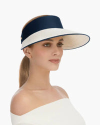 Woman wearing a wide-brimmed visor against a plain background., visirs, eric jarvis hat