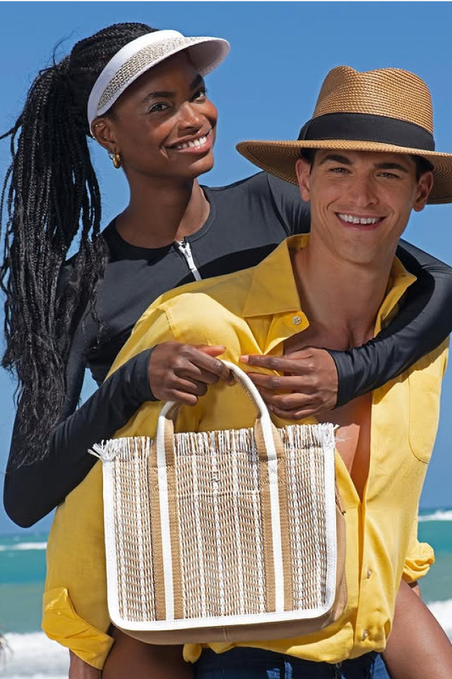 Couple enjoying a beach day, with a straw hat and bag.