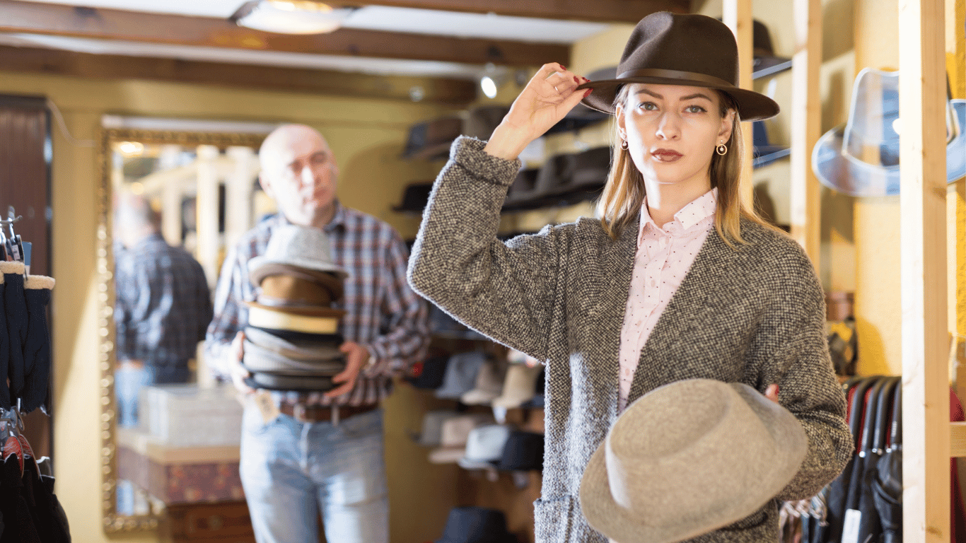 woman holding two hats